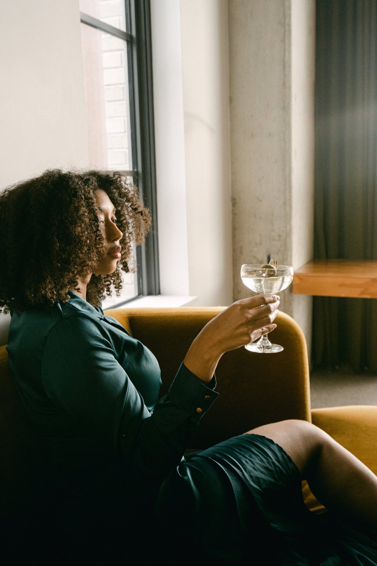 girl sitting on couch with a martini in her hand