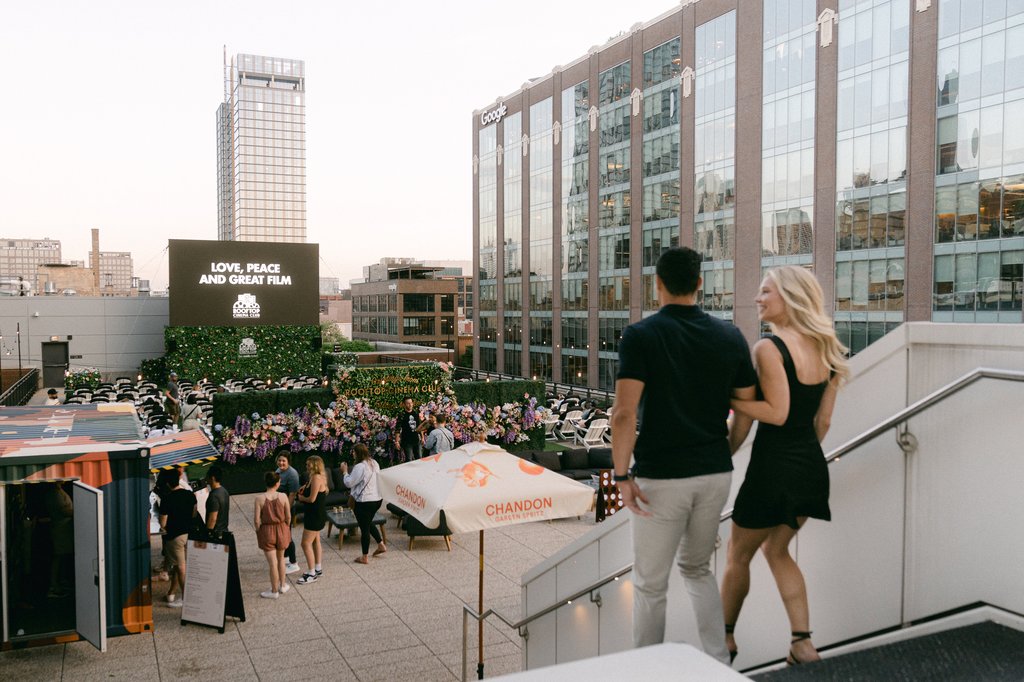 Couple walking down stairs to 5th floor terrace where rooftop cinema club is hosting movie nights for people in Chicago at the Emily Hotel