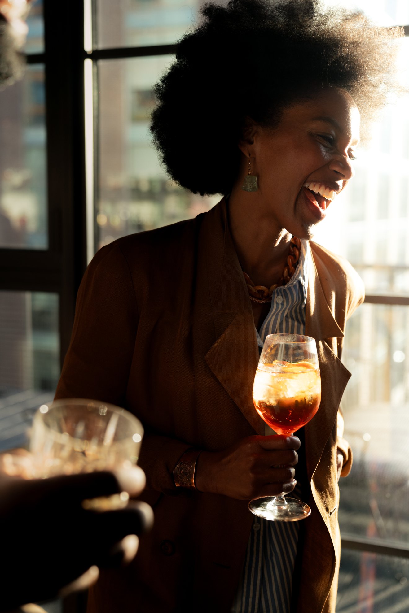 woman in selva with an aperol spritz in her hand