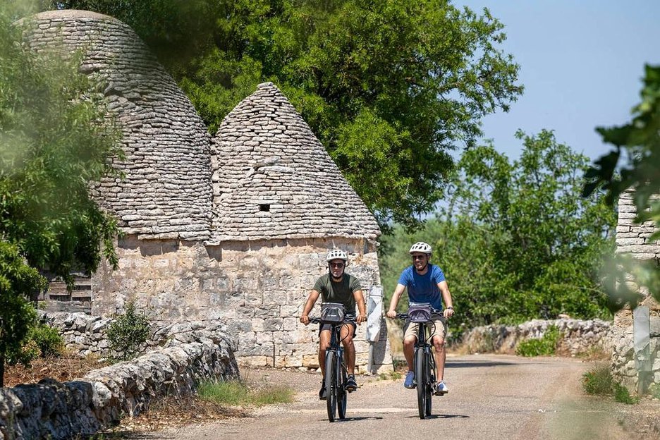 Two bikers by a trulli in Puglia