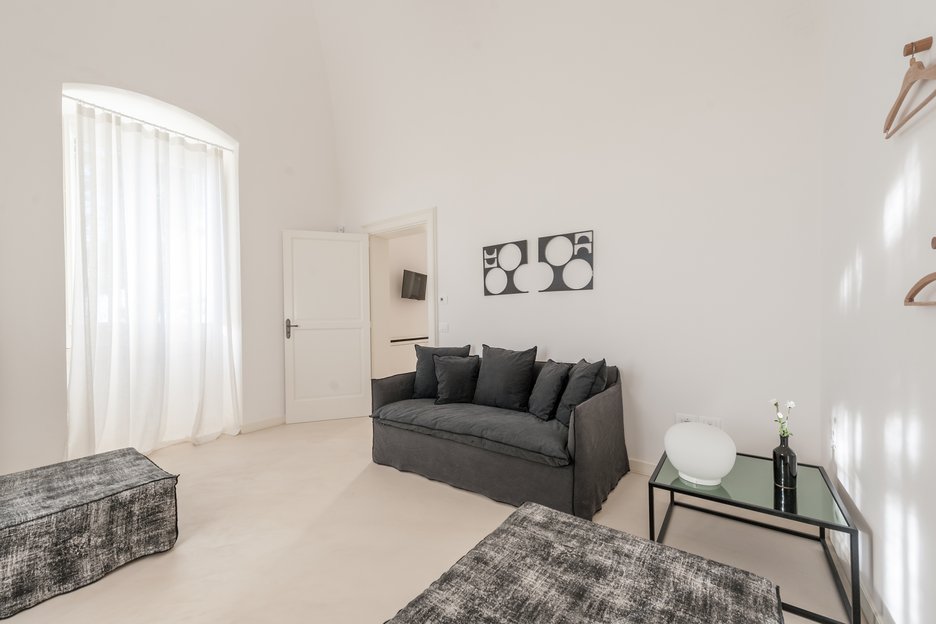 living area with grey couch in rosa junior suite at villa torre bianca by emily hotels