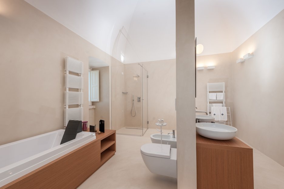 spacious bathrom with bath tub and two sinks in rosa junior suite at villa torre bianca by emily hotels in puglia italy