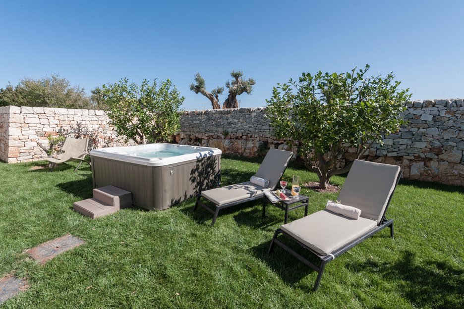 two lounge chairs and outdoor hot tub in emilia junior suite at villa torre bianca by emily hotels