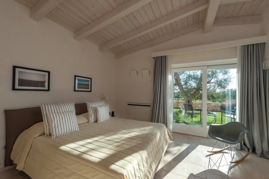 spacious bedroom with premium linen and garden view at villa torre bianca by emily hotels in puglia italy