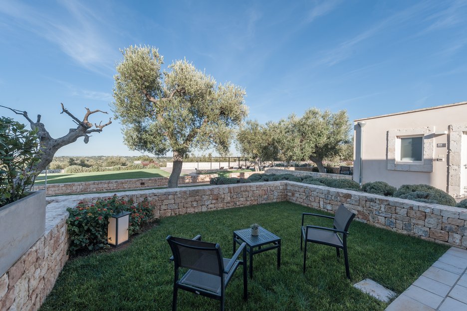 garden view with outdoor furniture in deluxe garden room at villa torre bianca by emily hotels