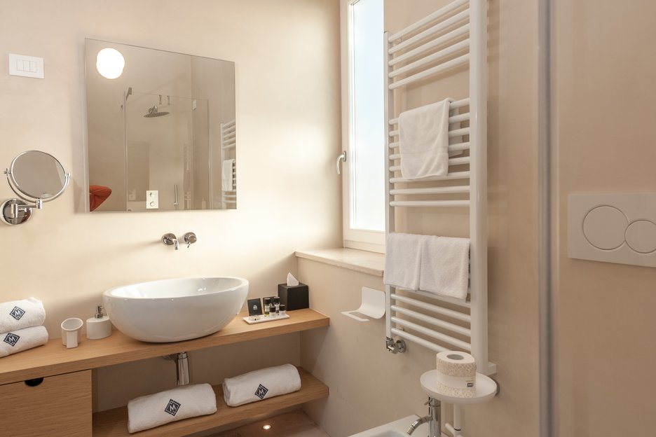 modern bathroom with amenities and standing shower in deluxe garden room at villa torre bianca by emily hotels