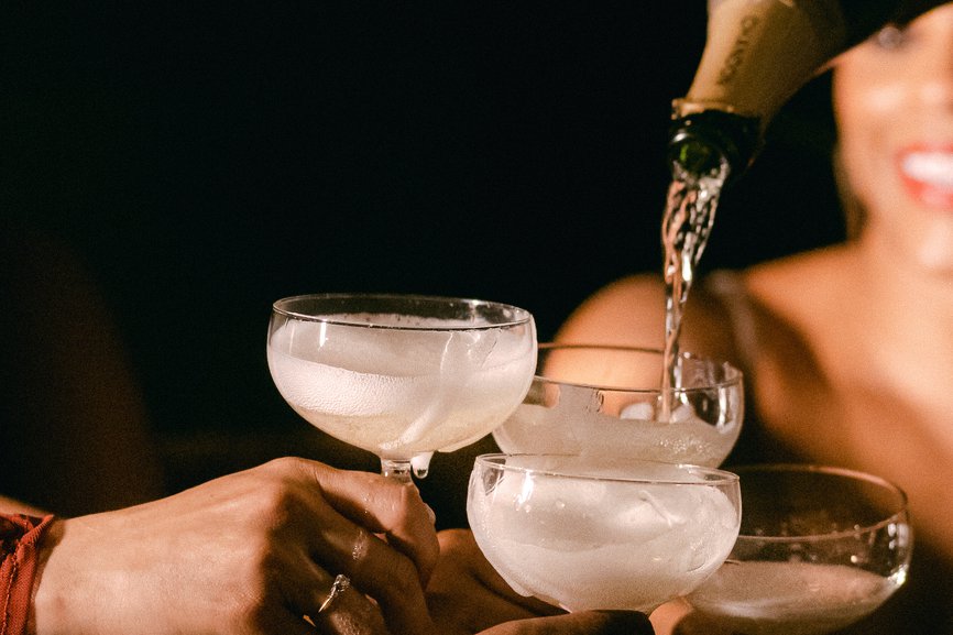 a woman pouring champagne into a glass, creating a sparkling cascade of bubbles and celebration at selva the emily hotel
