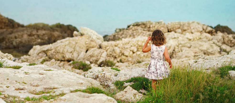 girl in puglia looking at ocean and rocks