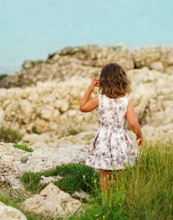 girl in puglia looking at ocean and rocks