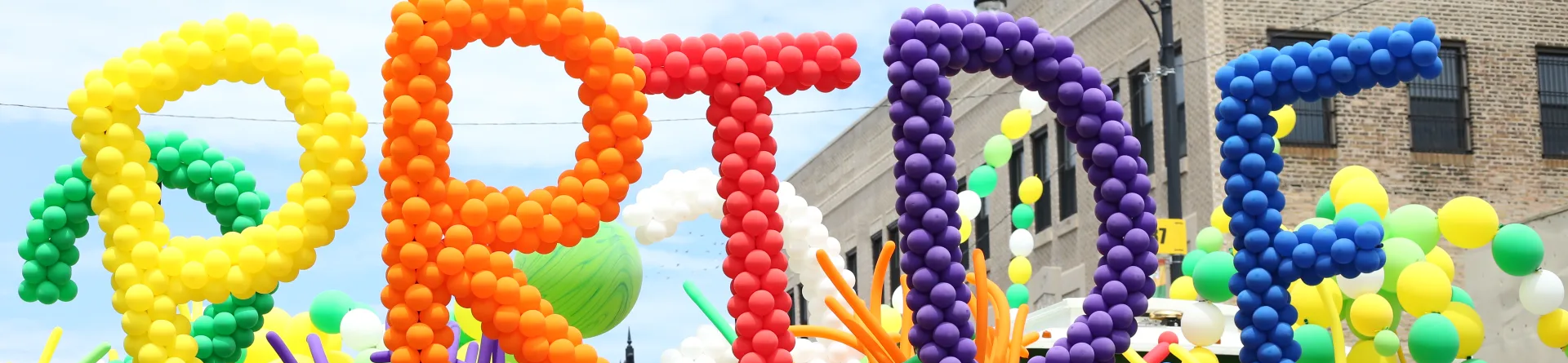 People standing with pride colored balloons in Chicago pride parade celebrating LGBTQ+