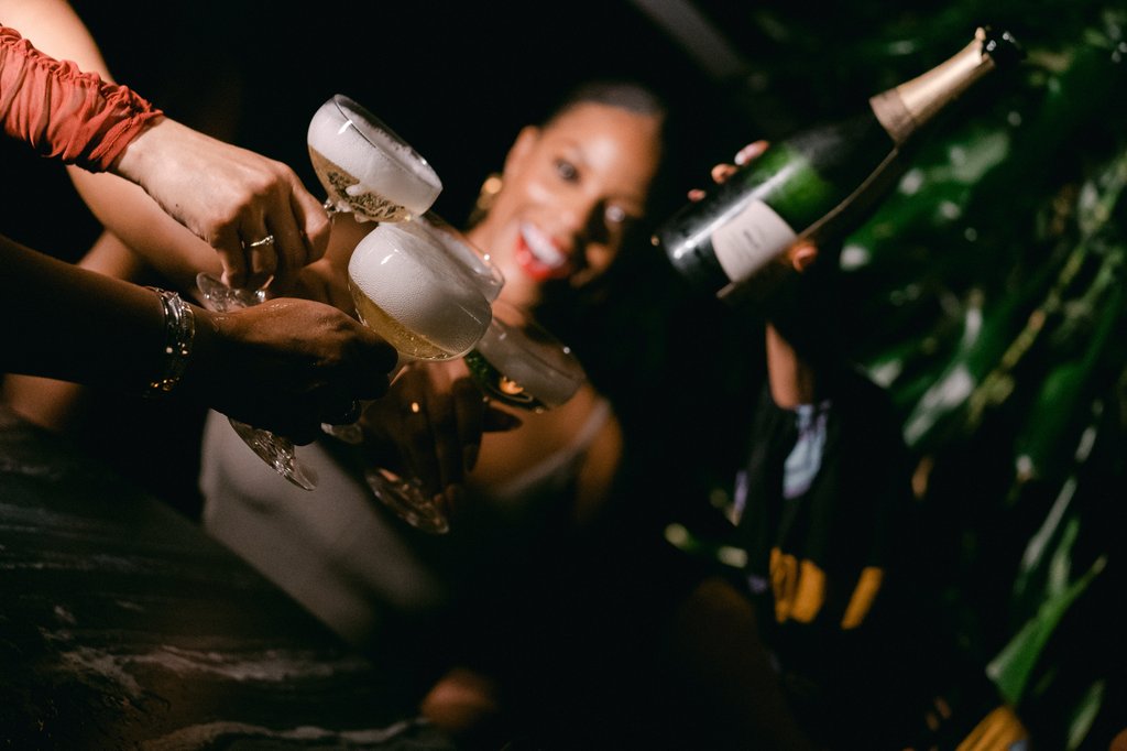 lively social gathering woman in a white dress smiling and pouring champagne at selva chicago the emily hotel fulton market