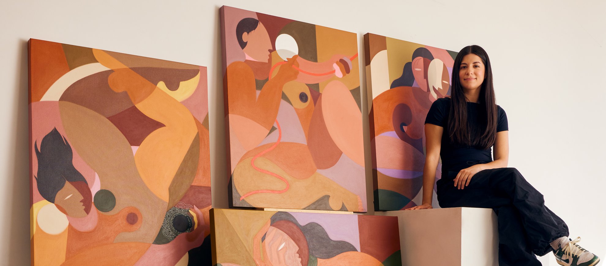 liz sittin on cube surrounded by paintings