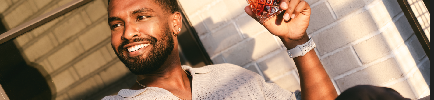 man sitting down with a negroni in his hand