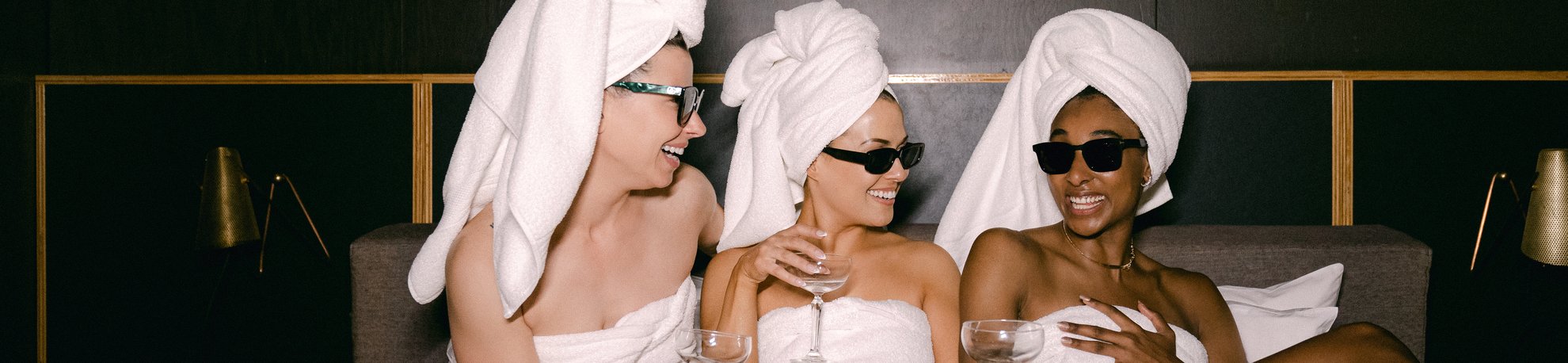 three girls holding a glass of champagne with chandon bottle in a jovial mood, interacting and smiling, and celebrate together at the emily hotel