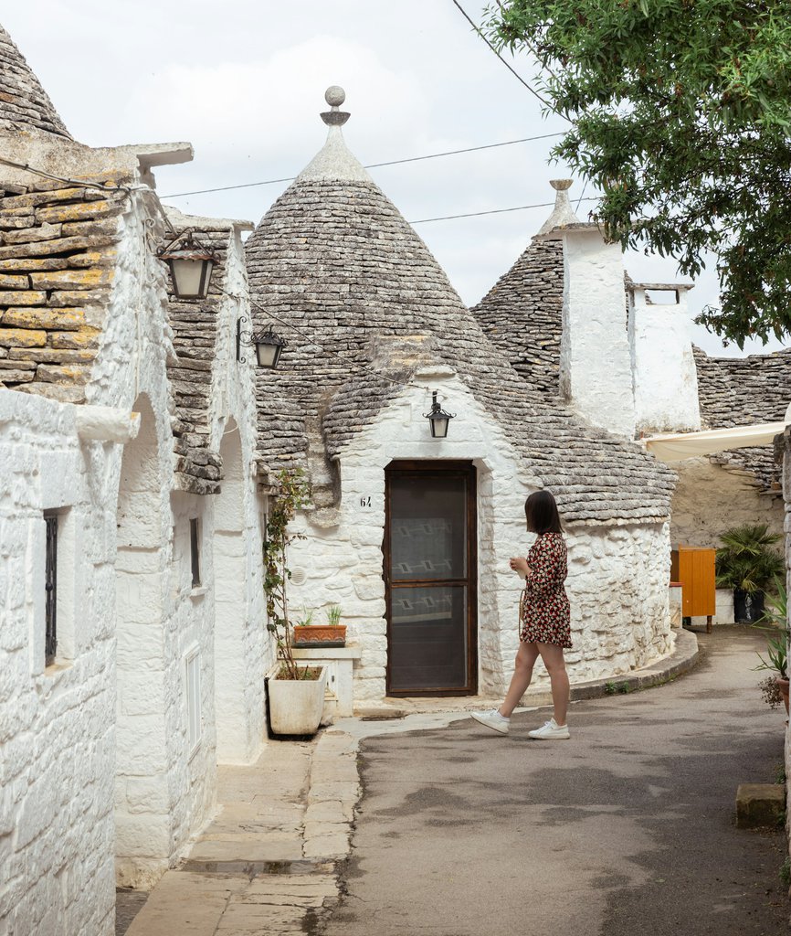 A lady explores the trulli houses of Alberobello